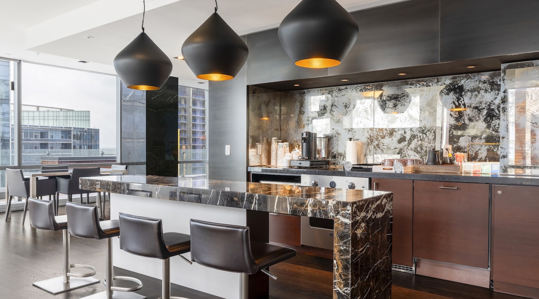 a clubroom kitchen with an island and chairs